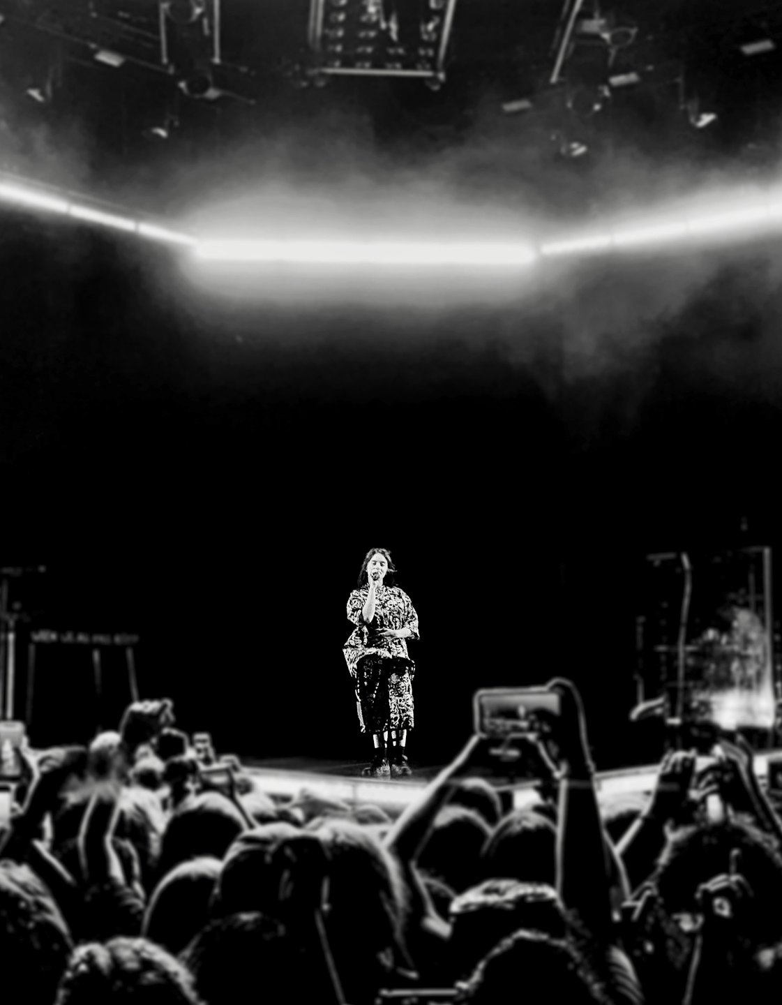 Un artista canta al microfono sul palco.