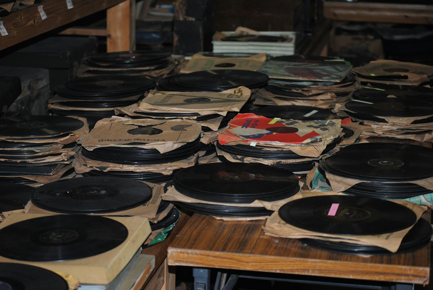 Pile di vecchi dischi in vinile dentro custodie di carta consumate.