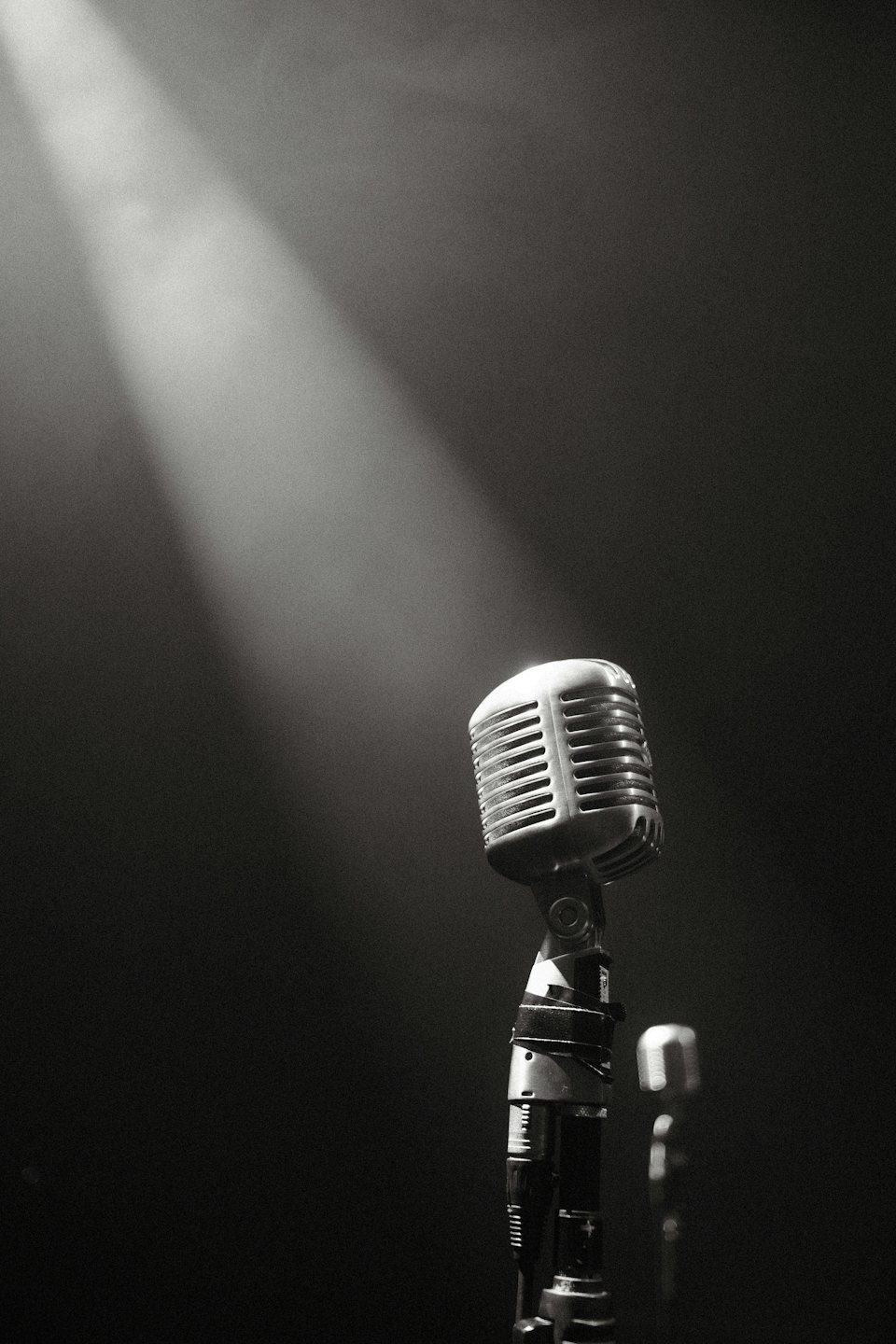 Un microfono metallico vintage su un palco scuro.