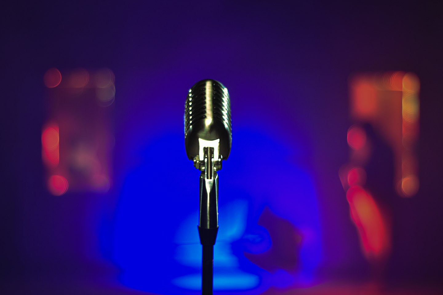 Un microfono d'argento vintage su un palco scuro.